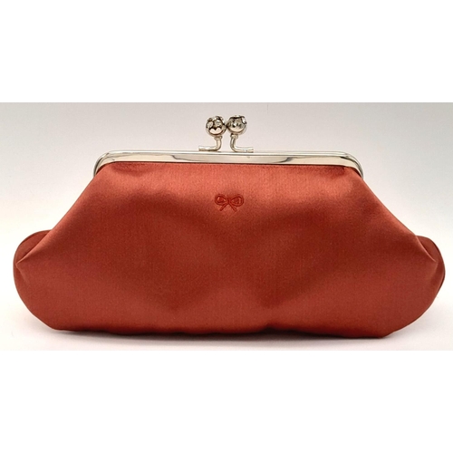 1418 - An Anya Red Clutch Bag. Satin exterior with silver-toned hardware, stone embellished kiss lock closu... 