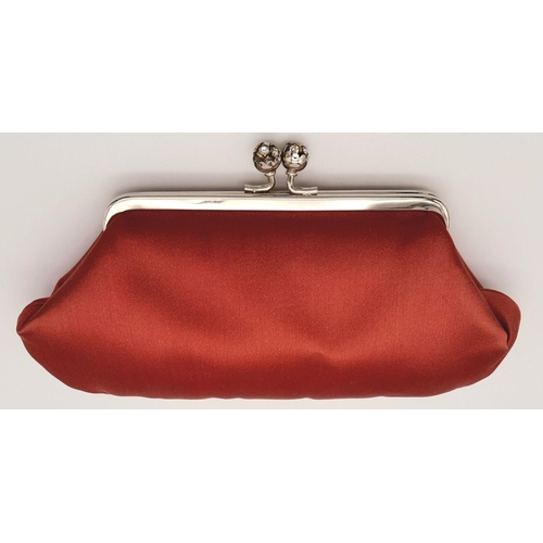 1418 - An Anya Red Clutch Bag. Satin exterior with silver-toned hardware, stone embellished kiss lock closu... 