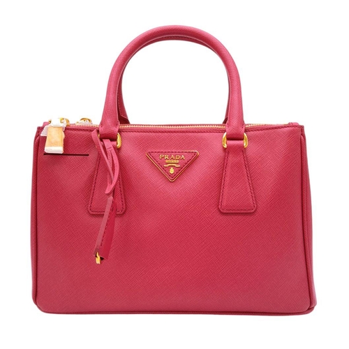 101 - A Prada Saffiano Vernice Galleria Handbag. Pink cross-grain saffiano leather exterior, gold-toned ha... 