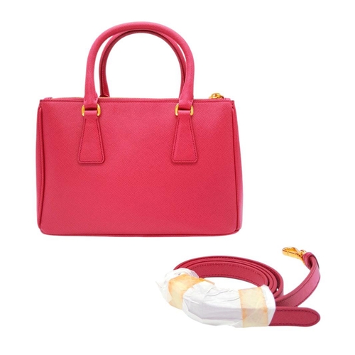 101 - A Prada Saffiano Vernice Galleria Handbag. Pink cross-grain saffiano leather exterior, gold-toned ha... 