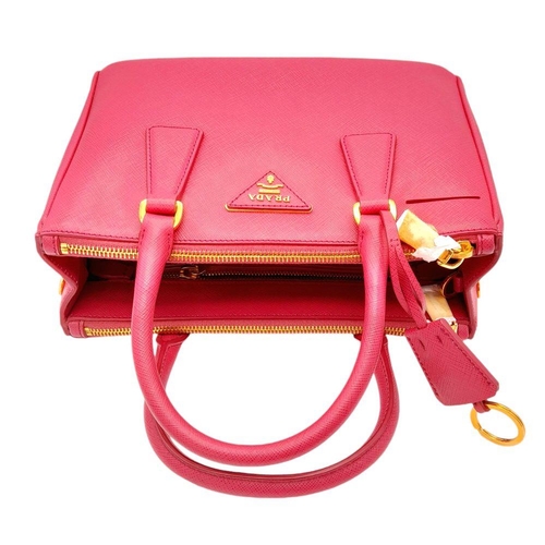 101 - A Prada Saffiano Vernice Galleria Handbag. Pink cross-grain saffiano leather exterior, gold-toned ha... 