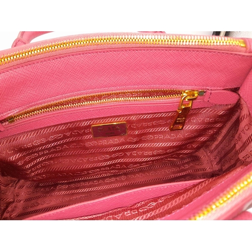 101 - A Prada Saffiano Vernice Galleria Handbag. Pink cross-grain saffiano leather exterior, gold-toned ha... 