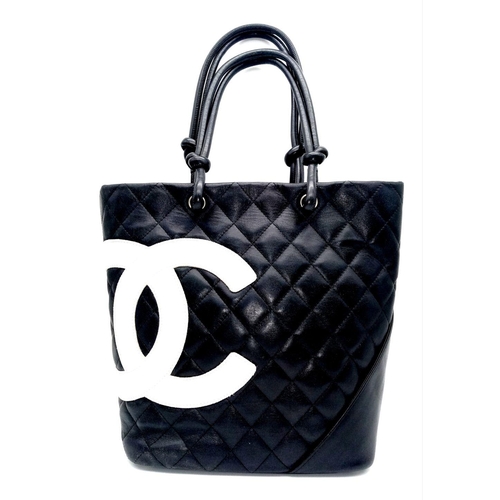 115 - A Chanel Cambon Leather Handbag. Black quilted leather exterior wit a large white Chanel monogram an... 