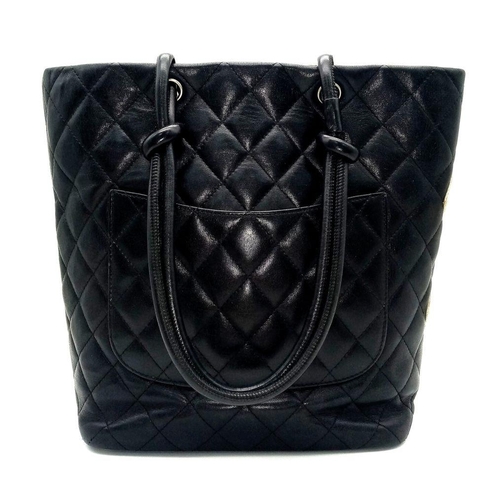 115 - A Chanel Cambon Leather Handbag. Black quilted leather exterior wit a large white Chanel monogram an... 