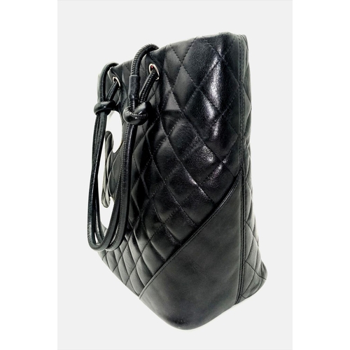 115 - A Chanel Cambon Leather Handbag. Black quilted leather exterior wit a large white Chanel monogram an... 