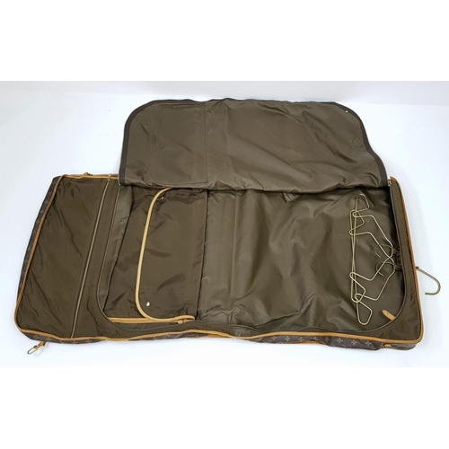 143 - A Louis Vuitton Suit Luggage Bag. Monogram canvas exterior. Brown leather trim and gold tone hardwar... 