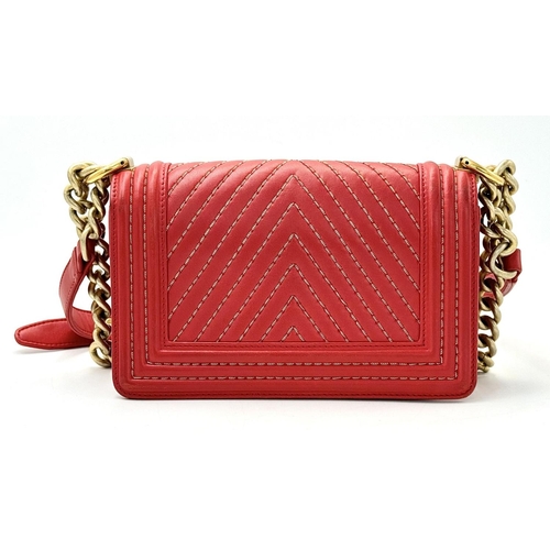 18 - A Chanel Lambskin Chevron Chain Stitched Boy Flap Bag. Red leather exterior features a chevron quilt... 