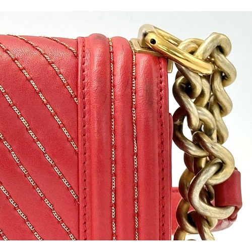 18 - A Chanel Lambskin Chevron Chain Stitched Boy Flap Bag. Red leather exterior features a chevron quilt... 