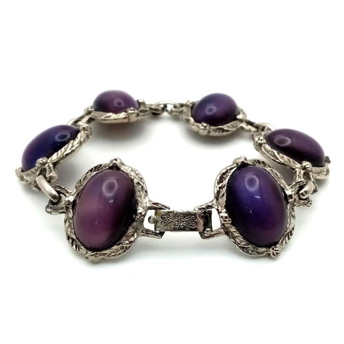 181 - A vintage, white metal (untested) bracelet with large cat’s eyes purple cabochons with exceptional l... 