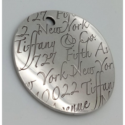 225 - A Tiffany and Co. Circular Fifth Avenue Inscription Pendant. 4cm diameter. 24.7g.