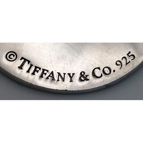 225 - A Tiffany and Co. Circular Fifth Avenue Inscription Pendant. 4cm diameter. 24.7g.