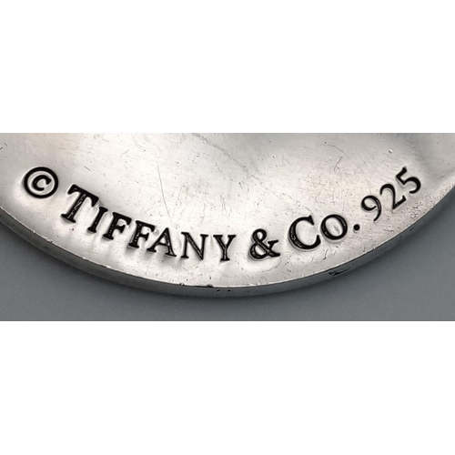 225 - A Tiffany and Co. Circular Fifth Avenue Inscription Pendant. 4cm diameter. 24.7g.