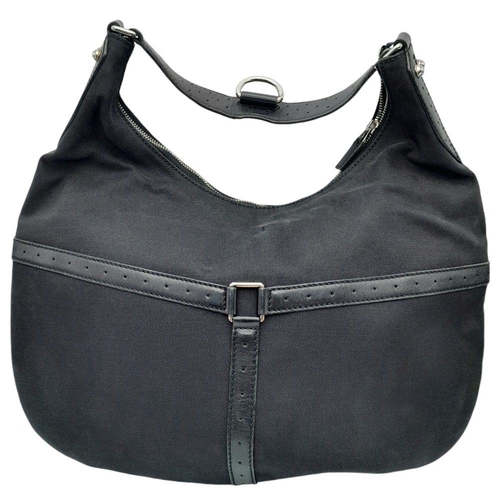 284 - A Gucci Black Canvas and Leather Hobo Bag. Black canvas and leather exterior with silver-toned hardw... 