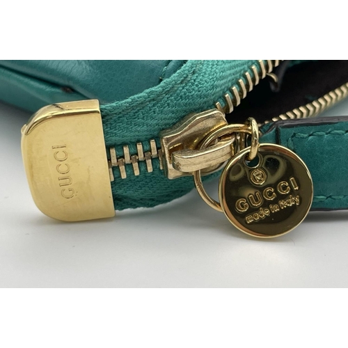 319 - A Gucci Green Leather Clutch Bag. Gold tone hardware. Zipped and open compartment interior. Authenti... 