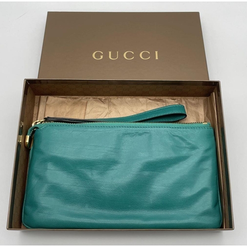 319 - A Gucci Green Leather Clutch Bag. Gold tone hardware. Zipped and open compartment interior. Authenti... 