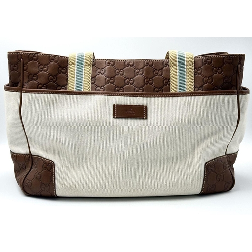 361 - A Vintage Gucci Canvas Shoulder Bag. Beige canvas exterior with brown leather trim, gold-toned hardw... 