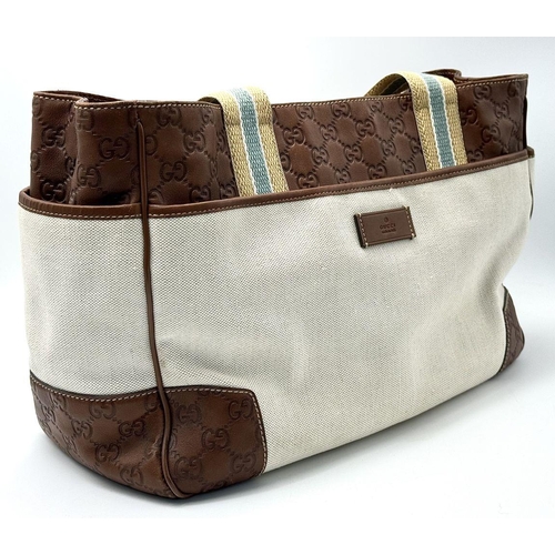 361 - A Vintage Gucci Canvas Shoulder Bag. Beige canvas exterior with brown leather trim, gold-toned hardw... 