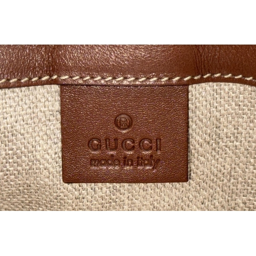 361 - A Vintage Gucci Canvas Shoulder Bag. Beige canvas exterior with brown leather trim, gold-toned hardw... 