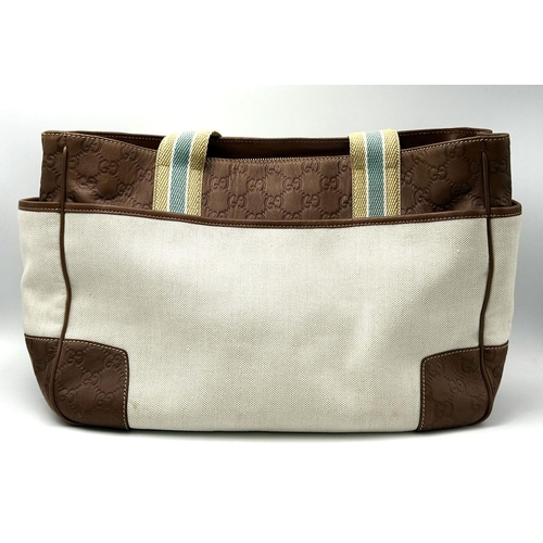 361 - A Vintage Gucci Canvas Shoulder Bag. Beige canvas exterior with brown leather trim, gold-toned hardw... 