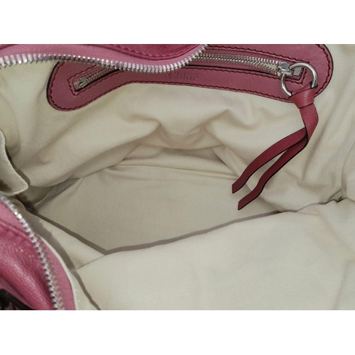 430 - A Chloe Fuchsia Leather Charm Detail Tote Bag. Pink leather exterior with gold-tone hardware and a d... 