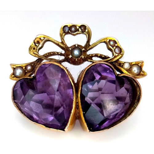 48 - An Antique 9K Gold (tested), Amethyst and Seed Pearl Brooch. Twin amethyst hearts. 3 x 2cm. Pin has ... 