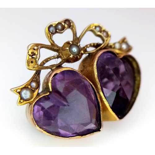 48 - An Antique 9K Gold (tested), Amethyst and Seed Pearl Brooch. Twin amethyst hearts. 3 x 2cm. Pin has ... 