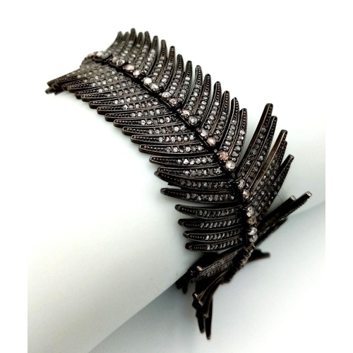 62 - A vintage – or possibly older- silver bracelet in the shape of a feather and covered with old cut di... 