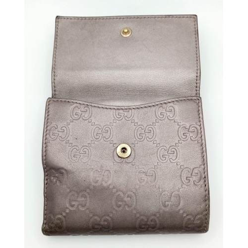 731 - A Gucci Decorative Monogram Purse/Wallet. Metallic effect leather. 12cm x 10cm. Ref: 019387