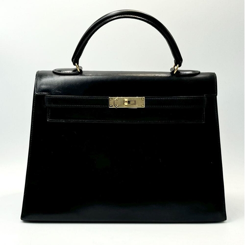 80 - A Hermès Box Kelly Sellier 32 Handbag. Black smooth calfskin leather exterior with gold-toned hardwa... 