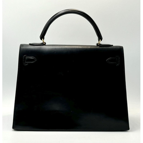 80 - A Hermès Box Kelly Sellier 32 Handbag. Black smooth calfskin leather exterior with gold-toned hardwa... 