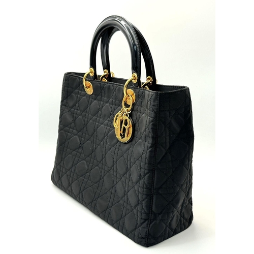 87 - A Christian Dior Black Quilted Tote Bag. Quilted fabric exterior with gold-toned hardware, rolled le... 