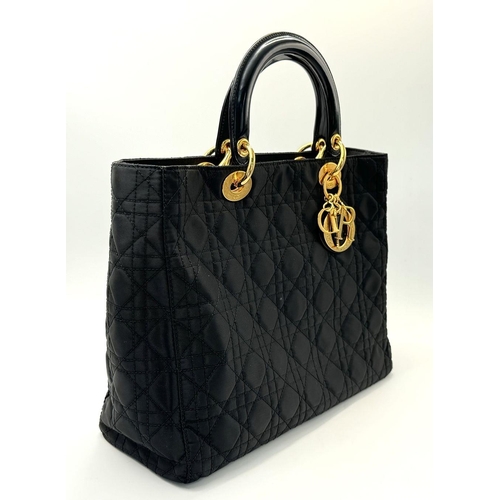 87 - A Christian Dior Black Quilted Tote Bag. Quilted fabric exterior with gold-toned hardware, rolled le... 