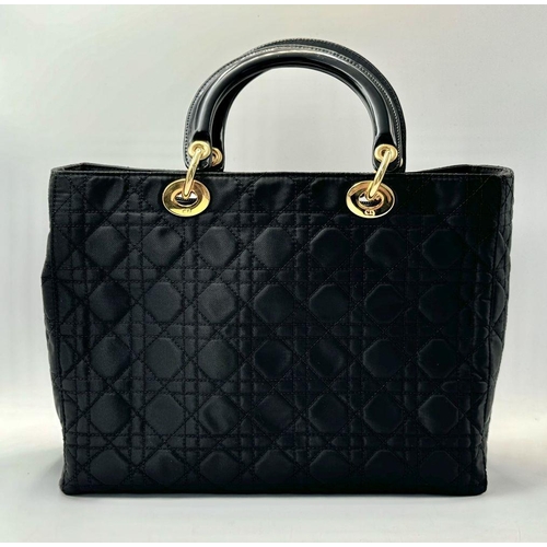 87 - A Christian Dior Black Quilted Tote Bag. Quilted fabric exterior with gold-toned hardware, rolled le... 