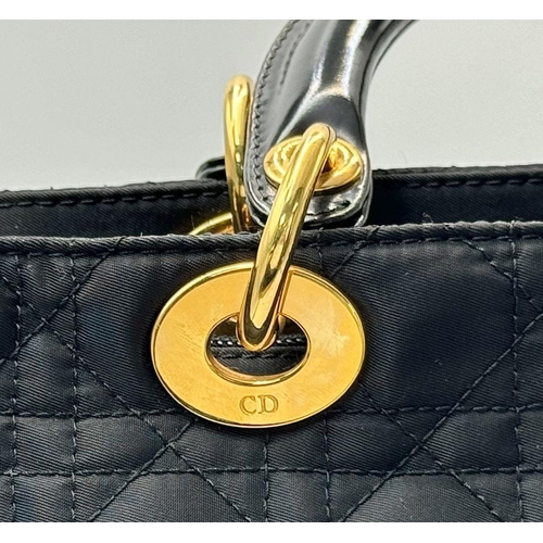 87 - A Christian Dior Black Quilted Tote Bag. Quilted fabric exterior with gold-toned hardware, rolled le... 