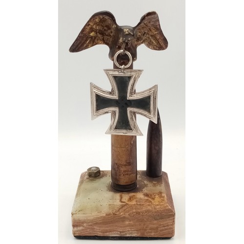 559 - A WW2 Iron Cross 2nd Class. Hooked on an eagles beak stand. One of the INERT bullet heads is missing... 