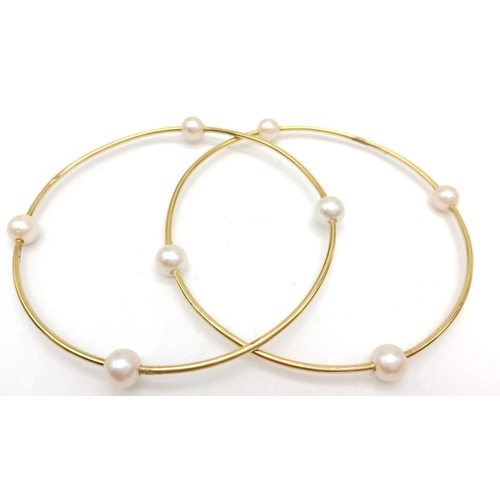 827 - A Pair of 18K Yellow Gold Bangles with Orbiting Pearl Decoration. 6cm inner diameter. 13.1g total we... 