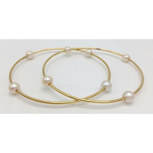 827 - A Pair of 18K Yellow Gold Bangles with Orbiting Pearl Decoration. 6cm inner diameter. 13.1g total we... 