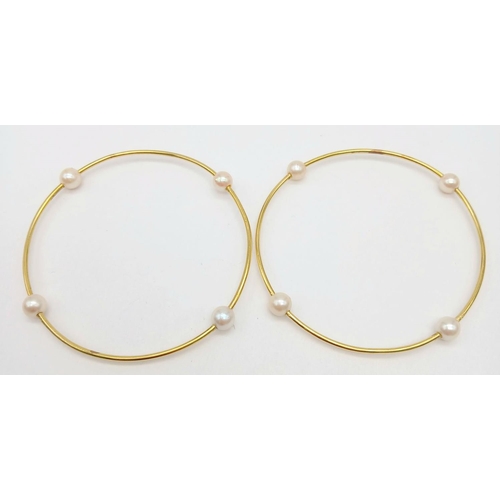 827 - A Pair of 18K Yellow Gold Bangles with Orbiting Pearl Decoration. 6cm inner diameter. 13.1g total we... 