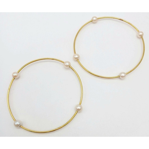 827 - A Pair of 18K Yellow Gold Bangles with Orbiting Pearl Decoration. 6cm inner diameter. 13.1g total we... 