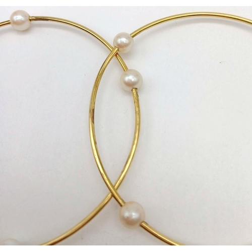 827 - A Pair of 18K Yellow Gold Bangles with Orbiting Pearl Decoration. 6cm inner diameter. 13.1g total we... 