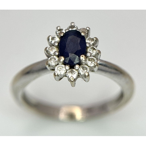 729 - A Classic Vintage 18K White Gold Sapphire and Diamond Ring. A deep blue oval cut central sapphire wi... 