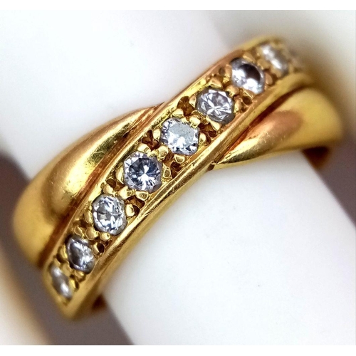 722 - An 18K Yellow Gold Diamond Crossover Ring. 0.30ctw of round cut diamonds. Size M 1/2. 7.9g total wei... 