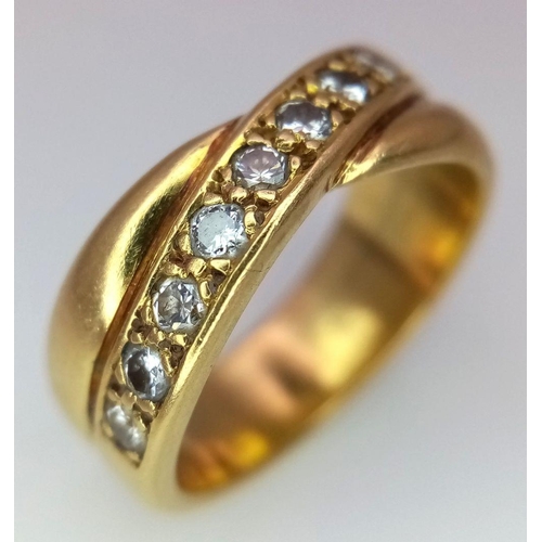 722 - An 18K Yellow Gold Diamond Crossover Ring. 0.30ctw of round cut diamonds. Size M 1/2. 7.9g total wei... 