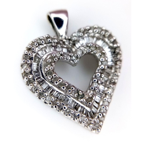 918 - A 14K White Gold and Diamond Heart Pendant. Pierced central heart with baguette and round cut diamon... 