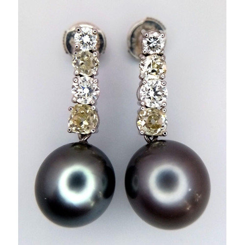 883 - A Pair of 18K White Gold, Diamond and Large Grey Pearl Drop Earrings. 1.6ctw of brilliant round cut ... 