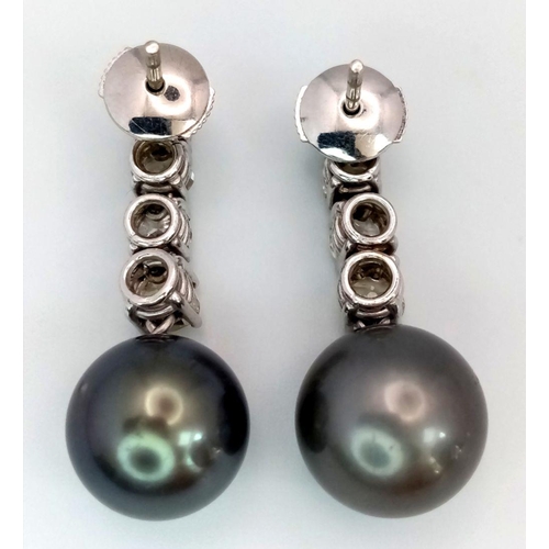 883 - A Pair of 18K White Gold, Diamond and Large Grey Pearl Drop Earrings. 1.6ctw of brilliant round cut ... 