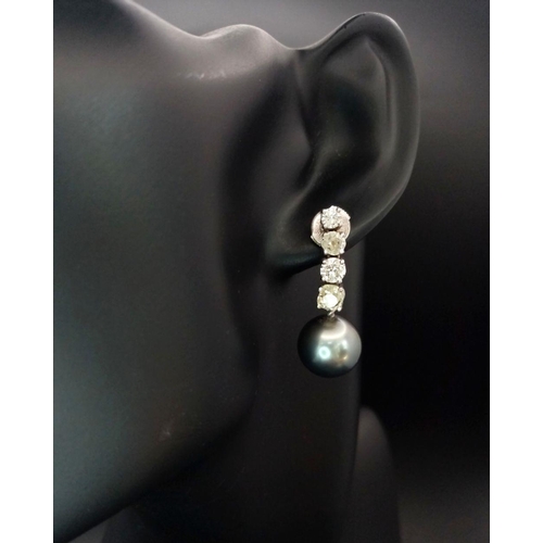 883 - A Pair of 18K White Gold, Diamond and Large Grey Pearl Drop Earrings. 1.6ctw of brilliant round cut ... 