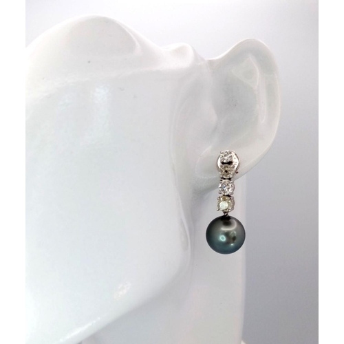 883 - A Pair of 18K White Gold, Diamond and Large Grey Pearl Drop Earrings. 1.6ctw of brilliant round cut ... 