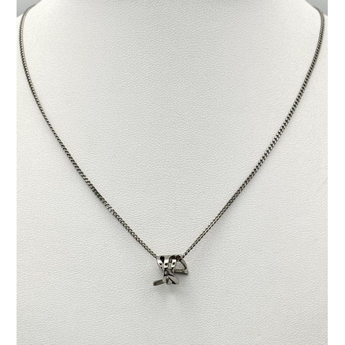 988 - A Designer Yves St. Laurent Pendant and Chain. White metal. 
10mm and 42cm. Ref: 18915