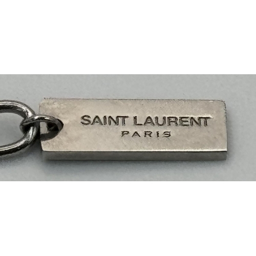 988 - A Designer Yves St. Laurent Pendant and Chain. White metal. 
10mm and 42cm. Ref: 18915